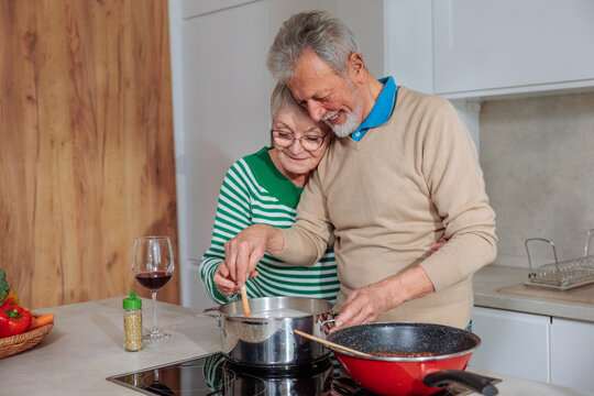 Senior couple cooking healthy meal together in kitchen