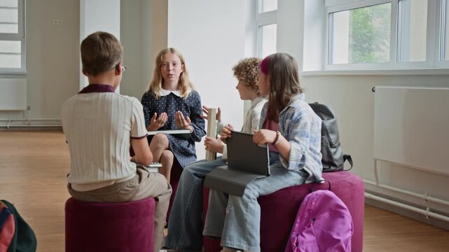 Caucasian school children discussing project together during break in hallway. Clip suitable for edtech advertising, school marketing, and educational promo videos