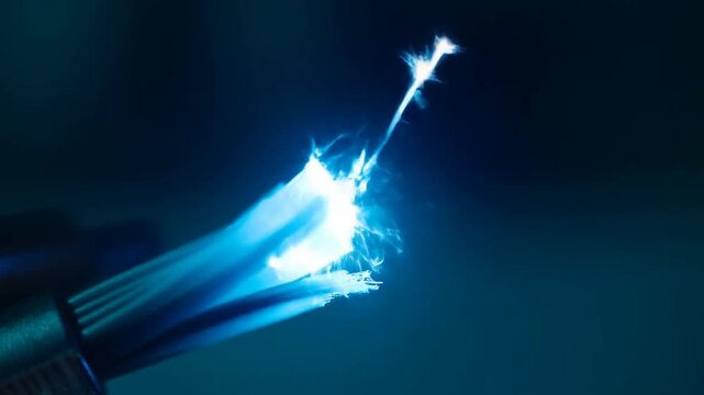 Frayed Fiber Optic Cable Emitting Blue Light Against a Dark Background