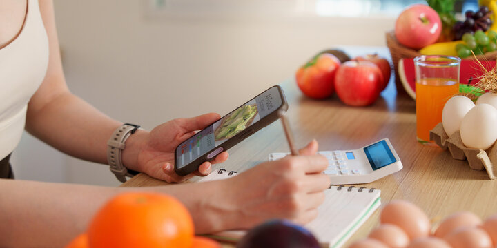 Cropped hands holding smartphone showing AI food scanner app for nutrition and calorie tracking