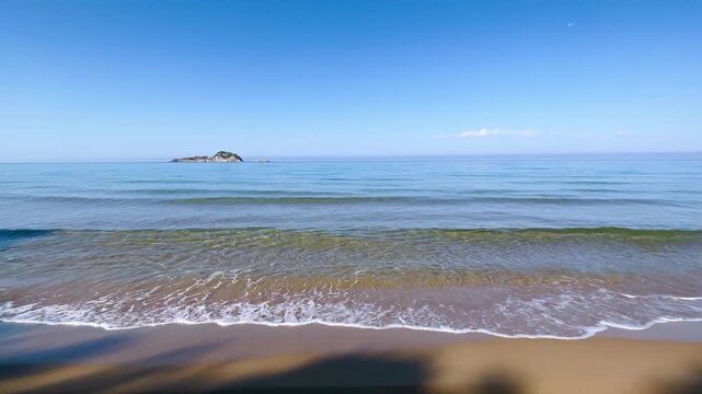 Wide angle view of rolling waves on the sandy shore of Paralia Arillas in Corfu, Greece