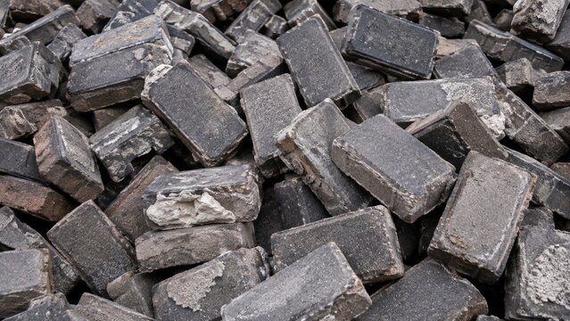 Pile of Old Weathered Dark Bricks and Construction Materials Close Up
