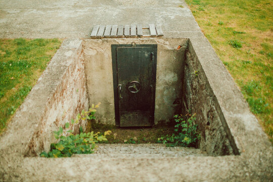 Entrance to an underground concrete bunker with a heavy metal sealed door