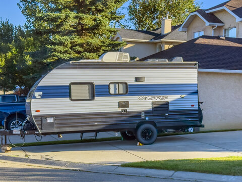 Calgary, Alberta, Canada. Sep 10, 2026. Side view of Wolf Pup travel trailer parked on concrete driveway in suburban residential driveway.