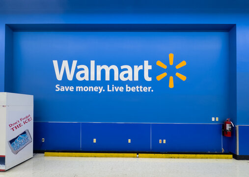 CALGARY, AB, CANADA - SEP 10, 2026: Straight-on view of the iconic blue Walmart logo wall and tagline at Sage Hill store interior entrance.