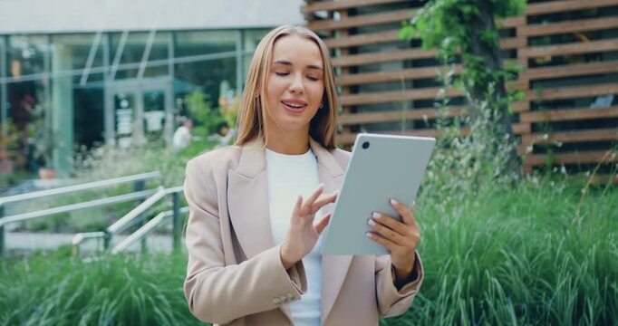 Young businesswoman girl lady woman using digital tablet typing on device outdoors smiling female employer real estate agent architect user gadget in city business downtown urban outside