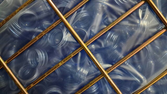 Blue Plastic Bottle Preforms in Metal Grid
