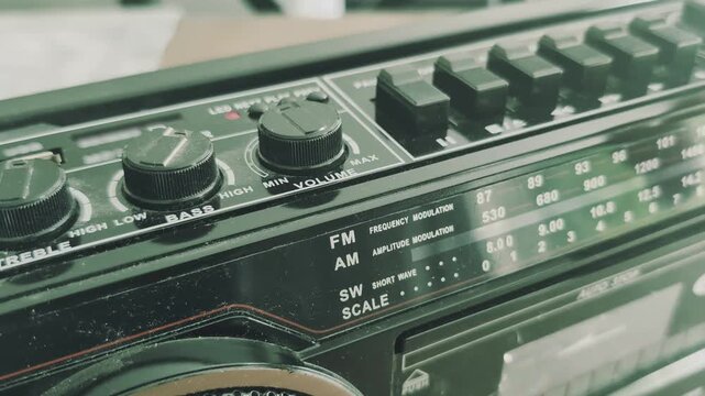 Inserting a cassette and turning on an old tape recorder from the eighties