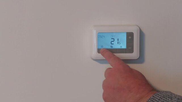 Adjusting the house thermostat to keep temperature comfortable