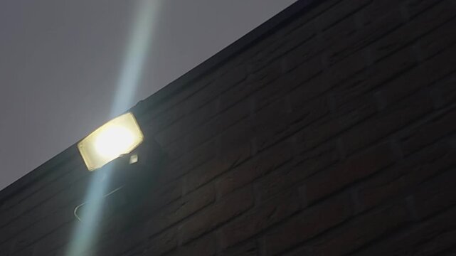 External LED light illuminates the building during evening hours in a city setting