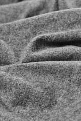 Close-up of soft gray wool felt fabric with deep folds and fuzzy textured surface, minimalist neutral background, vertical shot © Владимир Трубачёв