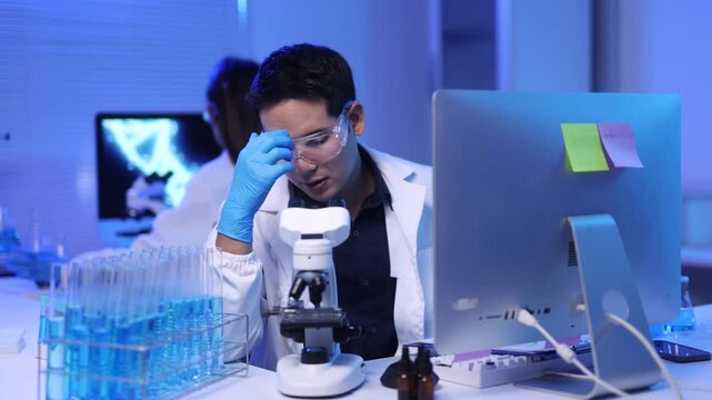 A young male scientist is conducting experiments in the laboratory with a stern expression.