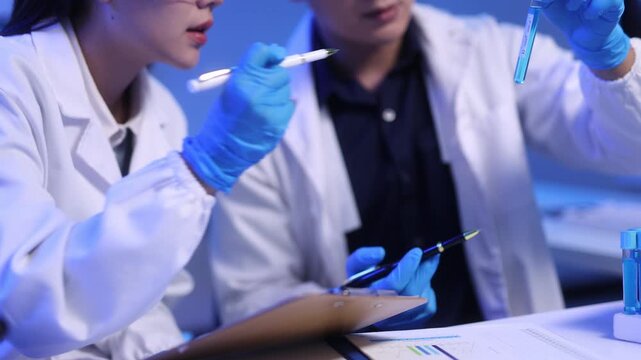 Close-up video of scientists conducting experiments in a laboratory.