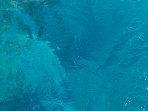 Rippled clear turquoise sea water surface in bright sunshine