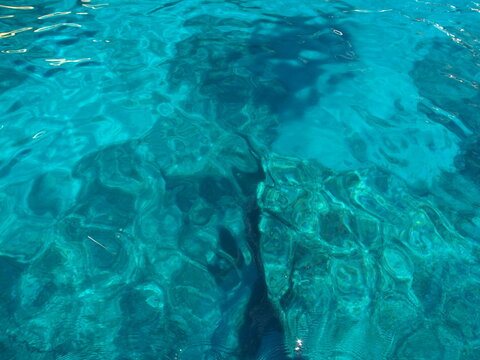Clear turquoise sea water revealing submerged rocky reef seabed