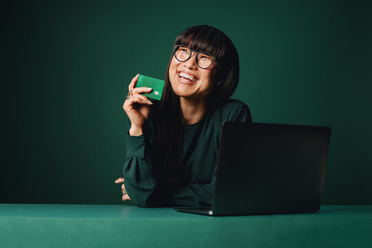 The woman reviews online payment details with a laptop and credit card