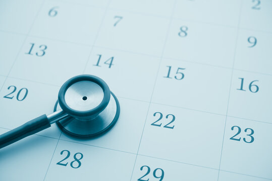 Stethoscope on white blank calendar background. Doctor appointment date reminder in hospital clinic center for health checkup, see condition and treatment. Healthcare, healthy lifestyle concept.