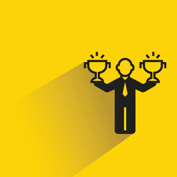 businessman rising trophy cups icon drop shadow on yellow background