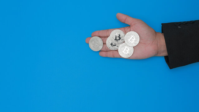 Hand holding silver coins shows confident crypto asset management for smart digital finance investment on blue background