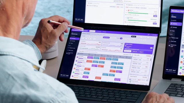 Mature Manager Points At Laptop Screen