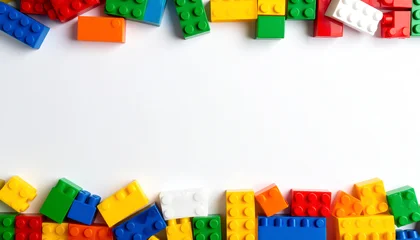 Bunte Plastik-Bausteine als Rahmen auf weißem Hintergrund © Sina Ettmer