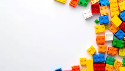 Bunte Plastik-Bausteine als Rahmen auf weißem Hintergrund © Sina Ettmer