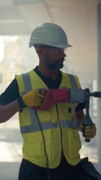 Vertical Screen. Building Construction Site with Workers. Portrait of Male Construction Worker Using a Professional Heavy Duty Rotary Hammer Drill to Bore Into a Concrete Wall Inside Office Building 