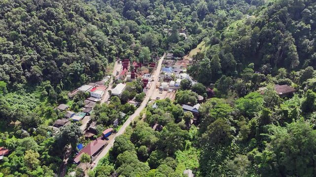 Flyover Mai Kampong village in narrow, thick Thailand jungle valley