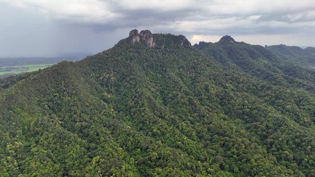 Rugged limestone peaks with thick Thai jungle under overcast sky