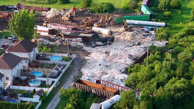 Large construction site adjacent to houses and greenery, aerial perspective.