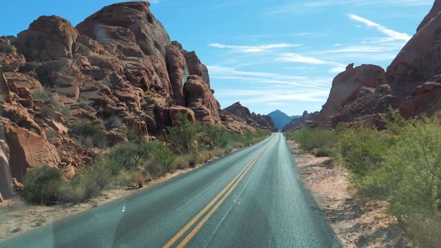 First-person perspective driving on a scenic desert highway through the majestic red rock formations of valley of fire state park in nevada, a popular american travel destination in the southwest