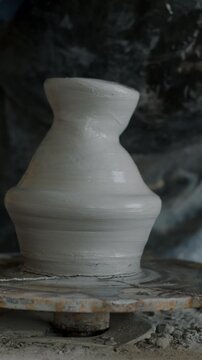 Close-up of potter's hands manufacturing ceramic vase using professional tools in workshop. Pottery technology and creative people concept.