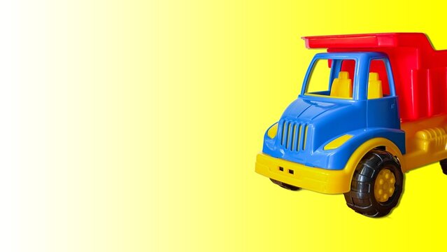 Toy dump truck on vibrant yellow and white gradient background, kids play vehicle design.