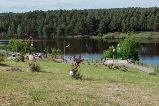 Scenic lakeside park with viewing platforms and forest on the opposite shore