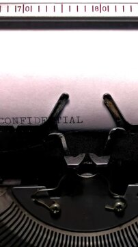 Vertical Macro Shot of Vintage Typewriter Typing the Word CONFIDENTIAL