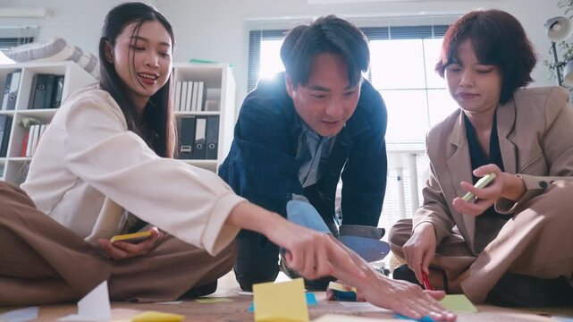 Business Asian team creating project mind map with colorful sticky notes