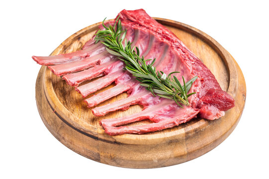 Uncooked rack of lamb, raw mutton chops on wooden board isolated on white background. top view