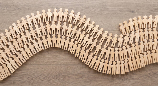 Flat wooden people cutouts arranged in wave photo for crowd community and society