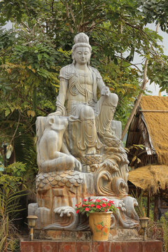 Stone Guanyin statue sitting on lunar zodiac monkey mount, traditional Asian astrology clever ape sculpture for intelligence and resourcefulness