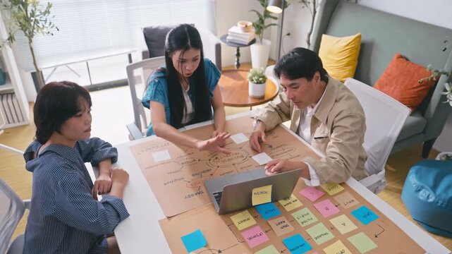 Business Asian team creating project mind map with colorful sticky notes