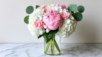 Obraz premium Elegant Pink Peony and White Hydrangea Floral Arrangement in Glass Vase on Marble Surface for Home Decor or Event Styling Ideas