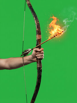 Human hand holding a traditional wooden bow with a flaming arrow isolated on a green screen background