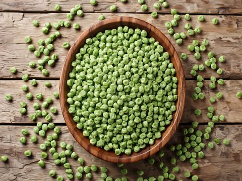 Top-down view of fresh green split peas in a wooden bowl on rustic wooden surface
