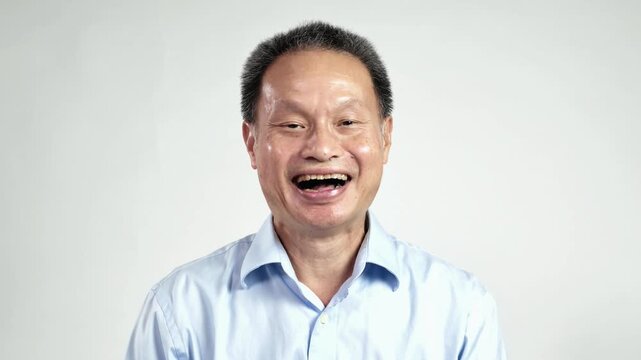 Slow Motion Portrait of Cheerful Senior Thai Man Laughing Out Loud