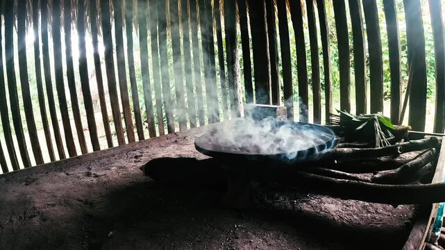 Traditional Indoor Cooking Fire in Ecuador Amazon Community, Smoke Rising From Clay Stove, Wooden Walls and Rural Jungle Food Preparation Scene