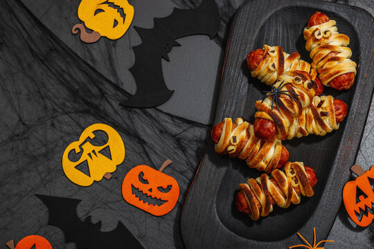 Spooky sausage mummies for Halloween party. Funny seasonal food, homemade baking, traditional decor