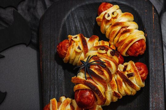 Spooky sausage mummies for Halloween party. Funny seasonal food, homemade baking, traditional decor