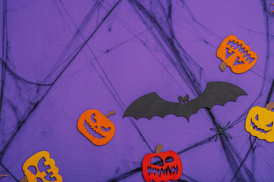 Funny Halloween background. Scary spider web, traditional fall pumpkins, bats and spiders