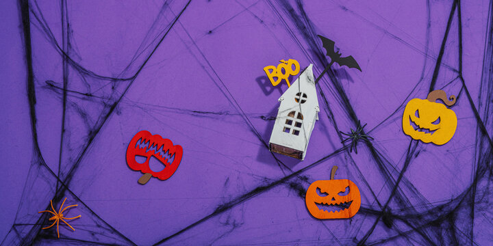 Funny Halloween background. Scary spider web, traditional fall pumpkins, house, bats and spiders