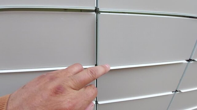 Close-up of a hand manually closing an empty locker door of an automated parcel delivery station